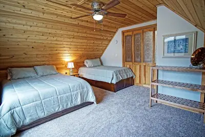 a bedroom with two beds and a ceiling fan at Pet Friendly, Firepit, Wrap around Porch, Close to Lake Granby and Highland Marina in Grand Lake