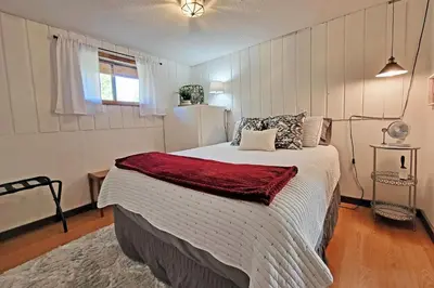 a bedroom with a large bed with a red blanket at New Listing, Great Backyard with Firepit, Pet Friendly, Wood Burning Stove in Grand Lake