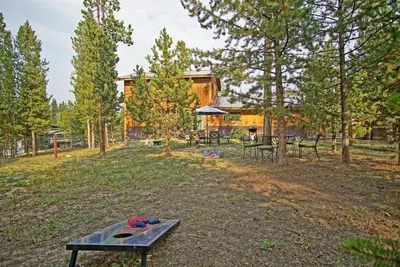 a picnic table in the yard of a log cabin at New Listing, Great Backyard with Firepit, Pet Friendly, Wood Burning Stove in Grand Lake