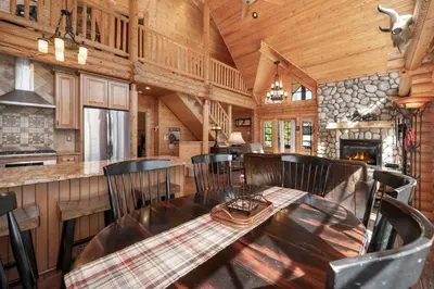 a dining room with a table and chairs in a cabin at Spacious Cabin - Quality Finishes & Furniture, 2 Large Bedroom Suites Plus Den Bedroom Suite in Grand Lake