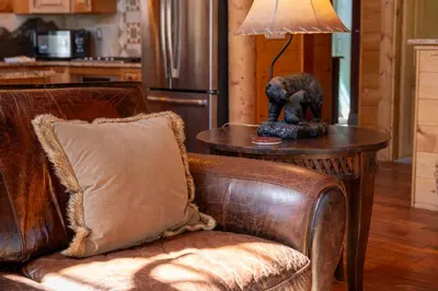 a table with a lamp on it next to a couch at Spacious Cabin - Quality Finishes & Furniture, 2 Large Bedroom Suites Plus Den Bedroom Suite in Grand Lake