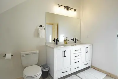 a bathroom with a sink and a toilet and a mirror at New Hot Tub, Firepit, Laundry, Big Front Deck with Great Views in Grand Lake