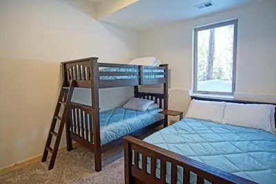 two bunk beds and a bed in a room at New Hot Tub, Firepit, Laundry, Big Front Deck with Great Views in Grand Lake