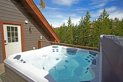a hot tub on the deck of a house at New Hot Tub, Firepit, Laundry, Big Front Deck with Great Views in Grand Lake