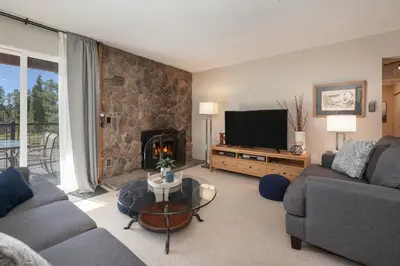 a living room with a couch and a television at Versatile Rental, Firepit, Balcony with Grill and Outdoor Seating in Fraser