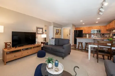 a large living room with a couch and a television at Versatile Rental, Firepit, Balcony with Grill and Outdoor Seating in Fraser