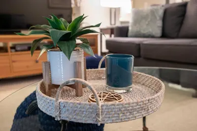 a basket table with a plant and a cup on it at Versatile Rental, Firepit, Balcony with Grill and Outdoor Seating in Fraser