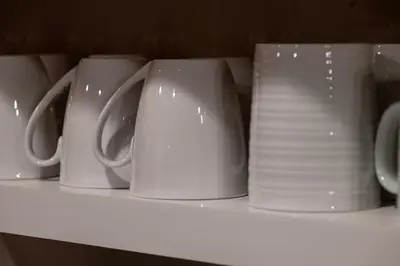 a row of white cups and plates on a shelf at Versatile Rental, Firepit, Balcony with Grill and Outdoor Seating in Fraser