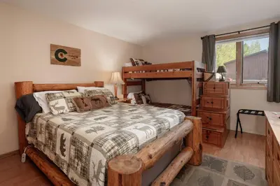 a bedroom with a wooden bed and a dresser at Lakefront Condo, Ground Floor, Ideal for Couples or Families in Grand Lake