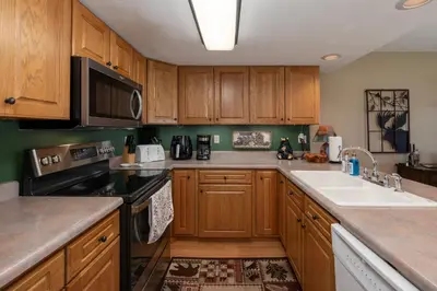 a kitchen with wooden cabinets and a sink at Lakefront Condo, Ground Floor, Ideal for Couples or Families in Grand Lake