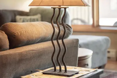 a lamp on a table in front of a couch at Lakefront Condo, Ground Floor, Ideal for Couples or Families in Grand Lake