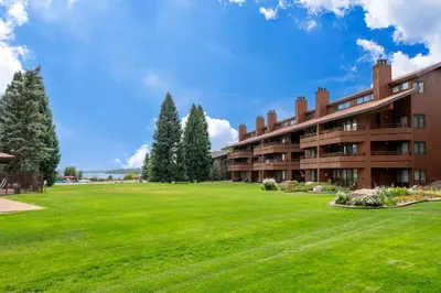 an apartment building with a large green yard at Lakefront Condo, Ground Floor, Ideal for Couples or Families in Grand Lake
