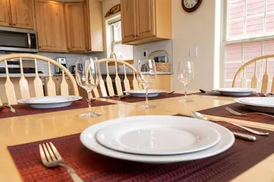 a table with a white plate and wine glasses on it at Private Garage, Washer and Dryer, Amazing Views of Byers Peak, Pet Friendly in Fraser