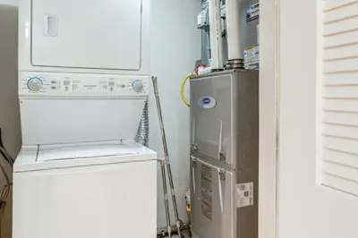 a small kitchen with a refrigerator and a washer at Pet-Friendly Retreat with Fenced Yard in Denver in Denver
