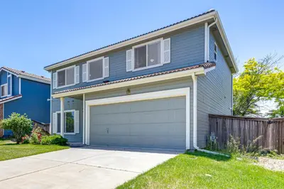a blue house with a garage in a yard at Pet-Friendly Retreat with Fenced Yard in Denver in Denver