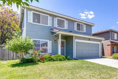 a blue house with a garage in a yard at Pet-Friendly Retreat with Fenced Yard in Denver in Denver