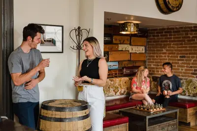 a man and a woman standing in a room with a barrel at Hostel Fish in Denver