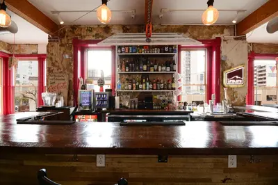 a bar with a large wooden counter in a room at Hostel Fish in Denver