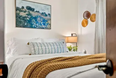 a white bedroom with a bed with a blanket at The Gather House Stylish Stay w Room to Play in Westminster
