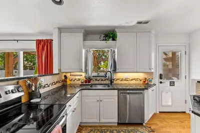 a kitchen with white cabinets and a sink at The Gather House Stylish Stay w Room to Play in Westminster