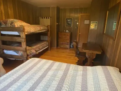 a bedroom with a bunk bed and a desk and a bed sidx sidx at Shadowcliff Rempel Lodge in Grand Lake