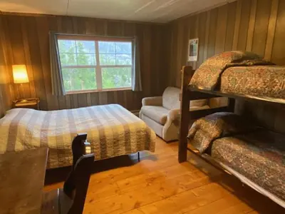 a bedroom with two bunk beds and a couch at Shadowcliff Rempel Lodge in Grand Lake