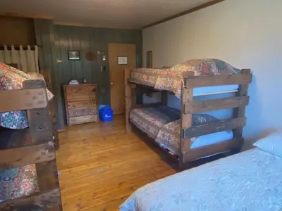 a bedroom with two bunk beds and a wooden floor at Shadowcliff Rempel Lodge in Grand Lake