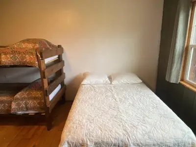 a small bedroom with a bed and a chair at Shadowcliff Rempel Lodge in Grand Lake