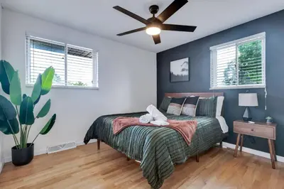 a bedroom with a bed and a ceiling fan at 4BD Near DT | Hot Tub, Pingpong & Backyard Fun in Arvada
