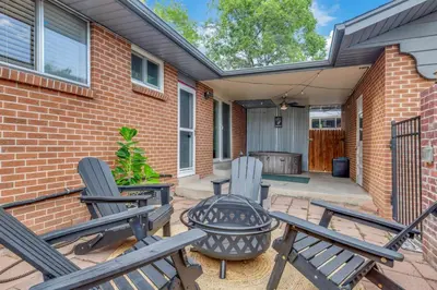 a patio with two chairs and a grill at 4BD Near DT | Hot Tub, Pingpong & Backyard Fun in Arvada