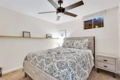 a bedroom with a bed and a ceiling fan at 4BD Near DT | Hot Tub, Pingpong & Backyard Fun in Arvada