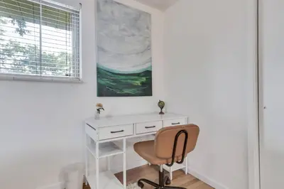 a desk and a chair in a room with a window at 4BD Near DT | Hot Tub, Pingpong & Backyard Fun in Arvada