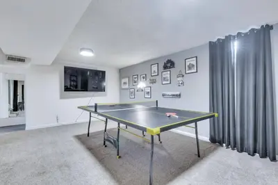 a ping pong table in the middle of a room at 4BD Near DT | Hot Tub, Pingpong & Backyard Fun in Arvada