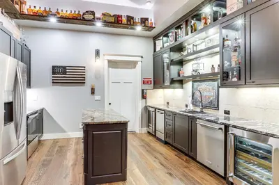 a large kitchen with black cabinets and stainless steel appliances at Private Hot Tub and Game Room Keenesburg Getaway! in Hudson