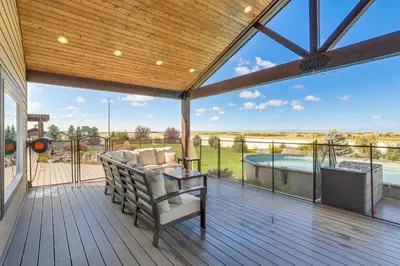 a screened in porch with a couch and a table and a pool at Private Hot Tub and Game Room Keenesburg Getaway! in Hudson