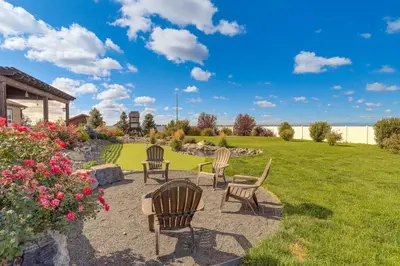 a patio with chairs and a grass yard at Private Hot Tub and Game Room Keenesburg Getaway! in Hudson
