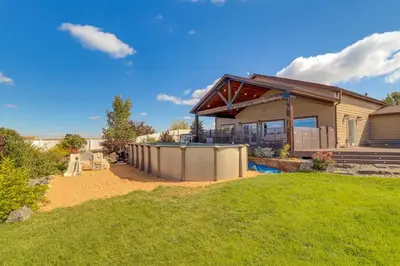 a house with a fence in front of a yard at Private Hot Tub and Game Room Keenesburg Getaway! in Hudson