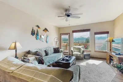 a living room with a couch and a ceiling fan at View House in Fraser