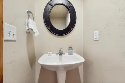 a bathroom with a sink and a mirror on the wall at View House in Fraser