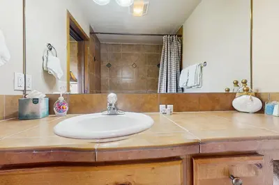 a bathroom with a sink and a mirror at View House in Fraser