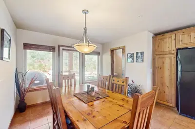 a kitchen and dining room with a wooden table and chairs at View House in Fraser