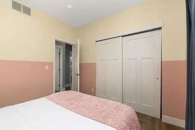 a bedroom with a bed and a closet at The Cycle Haus Rooftop Deck with Hot Tub and Views in Fort Collins