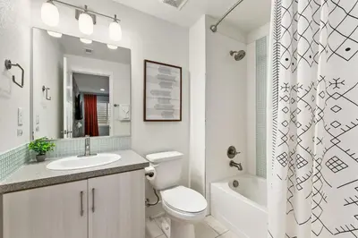 a bathroom with a toilet and a sink and a shower at The Cycle Haus Rooftop Deck with Hot Tub and Views in Fort Collins