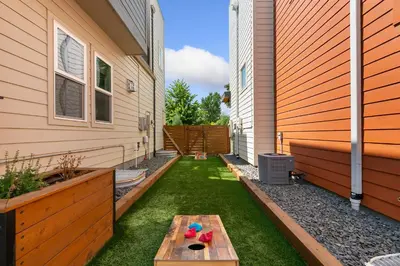 a small backyard with a table and grass at The Cycle Haus Rooftop Deck with Hot Tub and Views in Fort Collins
