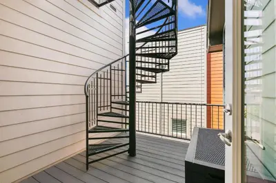 a spiral staircase on the side of a house at The Cycle Haus Rooftop Deck with Hot Tub and Views in Fort Collins