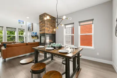 a living room with a table and a fireplace at The Cycle Haus Rooftop Deck with Hot Tub and Views in Fort Collins