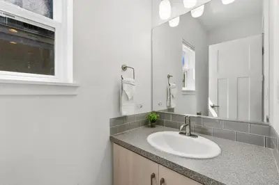 a bathroom with a sink and a mirror at The Cycle Haus Rooftop Deck with Hot Tub and Views in Fort Collins