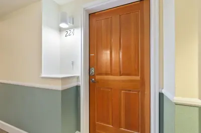 a wooden door in a hallway with a sign on it at Royal Perch - Chic Old Town Loft with King Suite in Fort Collins
