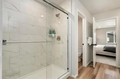 a bathroom with a shower with a glass door at Mosaic Modern - Dog Friendly, Pool and King Suite in Fort Collins