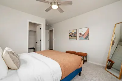 a bedroom with a bed and a ceiling fan at Mosaic Modern - Dog Friendly, Pool and King Suite in Fort Collins